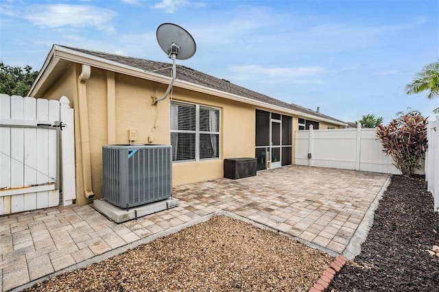 19351 Haskell Pl, Land O Lakes, FL 34638 - back of house with stucco siding, a gate, a fenced backyard, a sunroom, and a patio area
