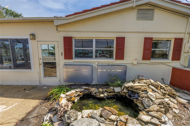 557 Crystal Dr, Madeira Beach, FL 33708 - view of side of home featuring a small pond