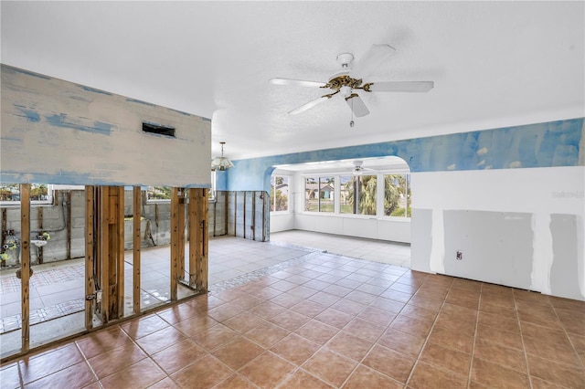 557 Crystal Dr, Madeira Beach, FL 33708 - unfurnished living room featuring ceiling fan, tile patterned floors, and arched walkways
