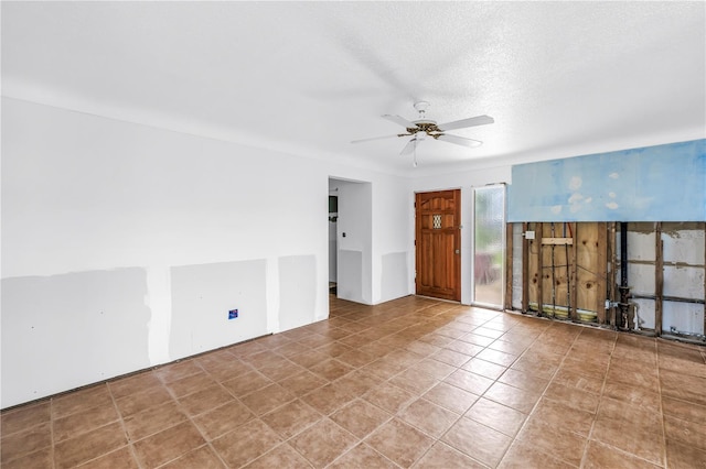 557 Crystal Dr, Madeira Beach, FL 33708 - tiled empty room with ceiling fan and a textured ceiling