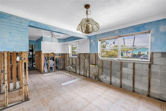 557 Crystal Dr, Madeira Beach, FL 33708 - unfurnished dining area with a textured ceiling, a chandelier, and ceiling fan