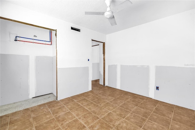 557 Crystal Dr, Madeira Beach, FL 33708 - unfurnished room featuring ceiling fan and a textured ceiling