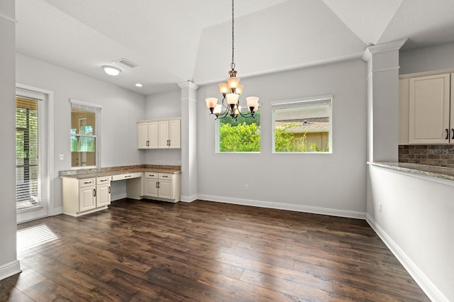 1304 Lorea Ln, Brandon, FL 33511 - unfurnished dining area featuring built in desk, decorative columns, dark wood-style flooring, a chandelier, and lofted ceiling