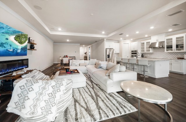 2516 Cobalt Shores Ln, Clearwater, FL 33761 - living area with dark wood finished floors, a glass covered fireplace, a tray ceiling, and recessed lighting