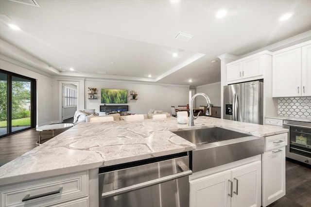2516 Cobalt Shores Ln, Clearwater, FL 33761 - kitchen with a raised ceiling, appliances with stainless steel finishes, open floor plan, dark wood-type flooring, and tasteful backsplash