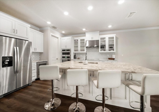 2516 Cobalt Shores Ln, Clearwater, FL 33761 - kitchen with crown molding, stainless steel appliances, decorative backsplash, a center island with sink, and white cabinets