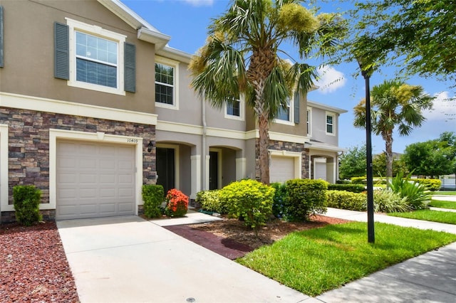 10409 Orchid Mist Ct, Riverview, FL 33578 - view of front facade featuring stone siding, stucco siding, an attached garage, and concrete driveway