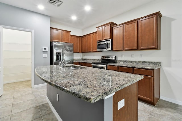 10409 Orchid Mist Ct, Riverview, FL 33578 - kitchen featuring appliances with stainless steel finishes, dark stone countertops, an island with sink, recessed lighting, and light tile patterned floors