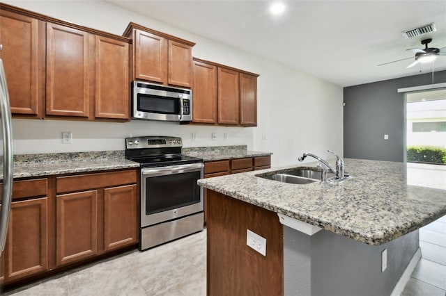10409 Orchid Mist Ct, Riverview, FL 33578 - kitchen with appliances with stainless steel finishes, light tile patterned flooring, light stone countertops, and ceiling fan