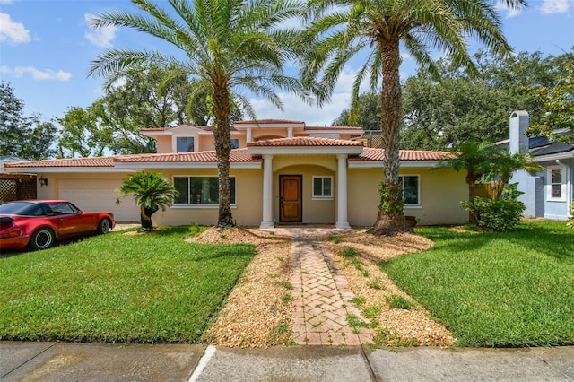 1020 Charles St, Clearwater, FL 33755 - mediterranean / spanish-style home with an attached garage, a front lawn, stucco siding, and a tiled roof