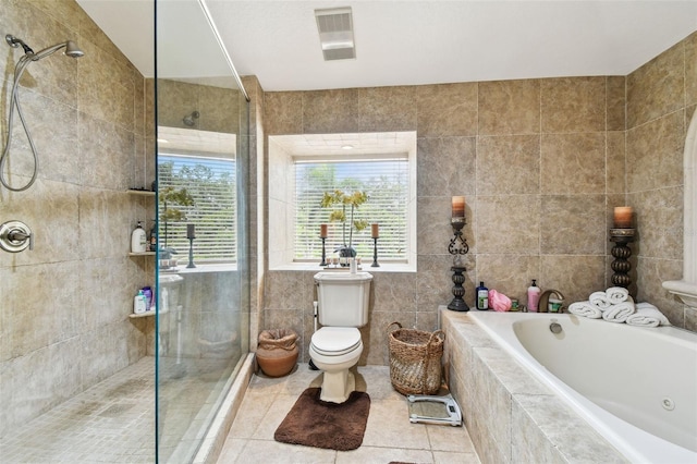 1020 Charles St, Clearwater, FL 33755 - bathroom with a jetted tub, tile patterned floors, a tile shower, and tile walls