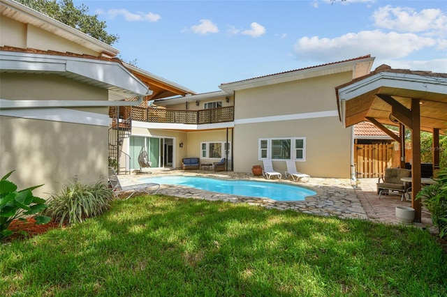 1020 Charles St, Clearwater, FL 33755 - back of property with stucco siding, a balcony, a patio, and an outdoor pool