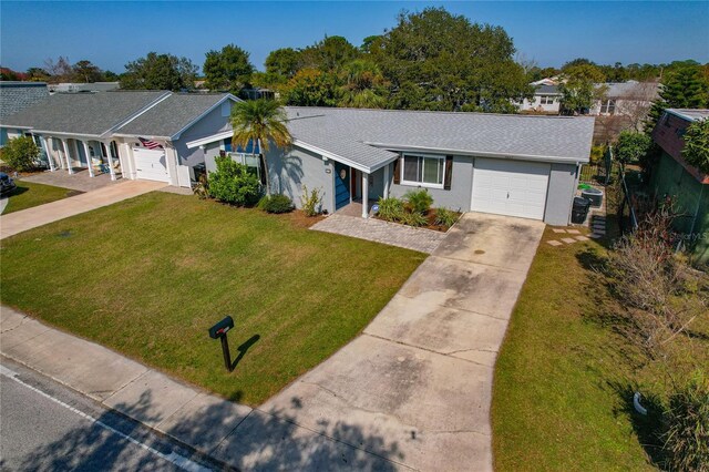 3823 Sail Dr, New Port Richey, FL 34652 - ranch-style home with driveway, an attached garage, a front lawn, stucco siding, and roof with shingles