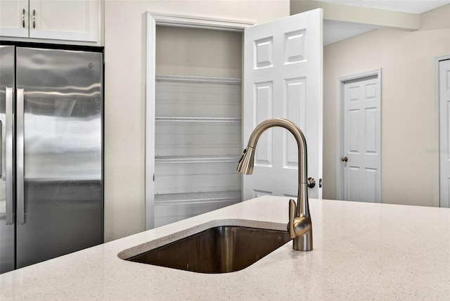 5413 Badini Way, Palmetto, FL 34221 - kitchen view of stainless steel fridge, light stone counters, and white cabinetry