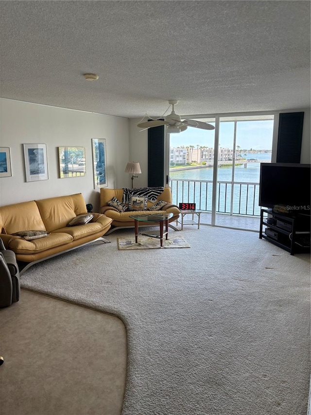7401 Bay Island Dr S Unit 338, South Pasadena, FL 33707 - living area featuring carpet, ceiling fan, a wall of windows, and a textured ceiling