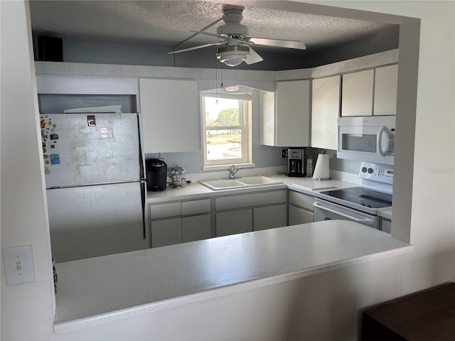 7401 Bay Island Dr S Unit 338, South Pasadena, FL 33707 - kitchen with white appliances, ceiling fan, a textured ceiling, light countertops, and white cabinets