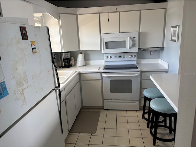 7401 Bay Island Dr S Unit 338, South Pasadena, FL 33707 - kitchen featuring white appliances, light tile patterned flooring, and light countertops