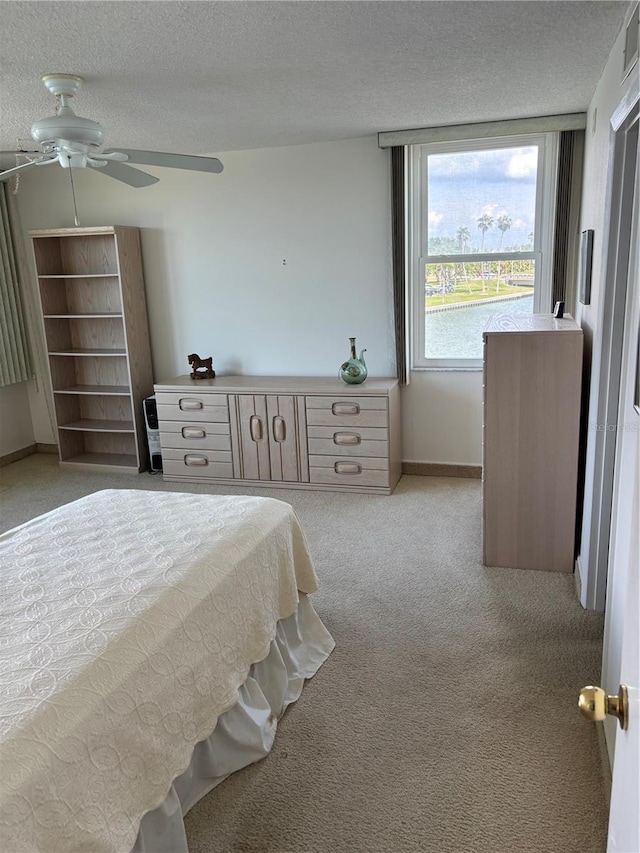 7401 Bay Island Dr S Unit 338, South Pasadena, FL 33707 - bedroom with light colored carpet, a textured ceiling, and a ceiling fan