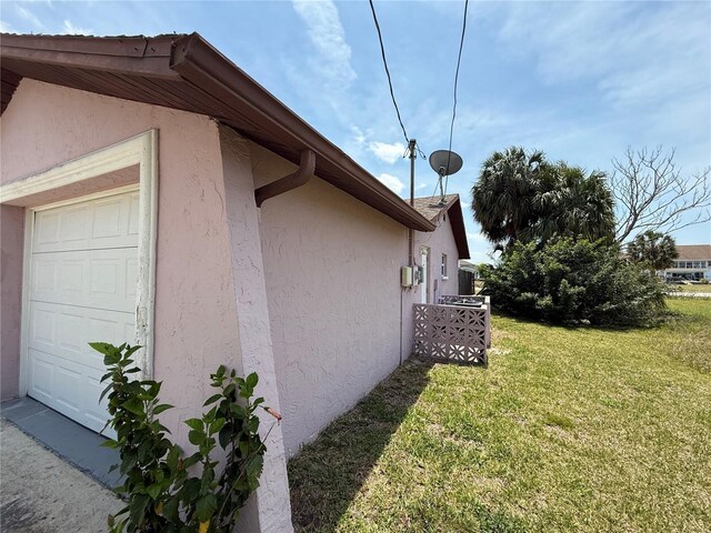7400 Mako Dr, Hudson, FL 34667 - view of home's exterior with a garage, stucco siding, and a lawn