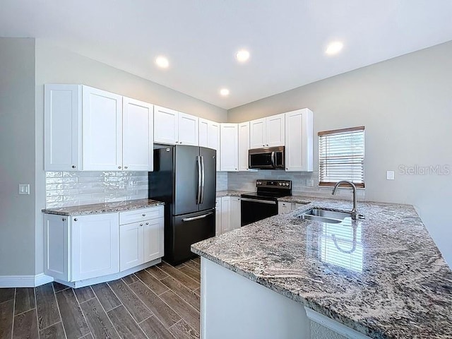 2049 Darlington Oak Dr, Seffner, FL 33584 - kitchen with stainless steel microwave, electric range oven, freestanding refrigerator, a peninsula, and light stone countertops