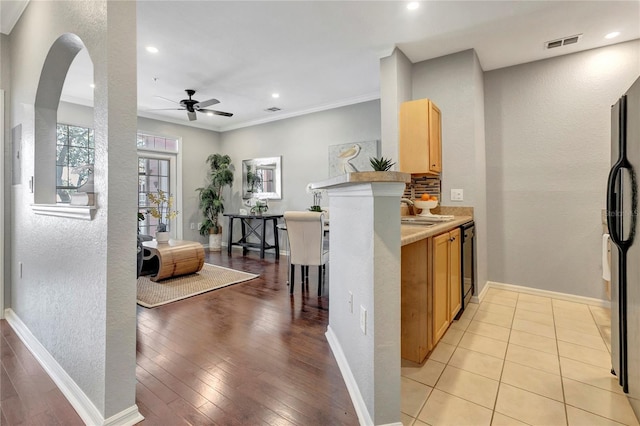 5000 Culbreath Key Way Unit 8-106, Tampa, FL 33611 - kitchen featuring a ceiling fan, light wood finished floors, black dishwasher, crown molding, and a textured wall