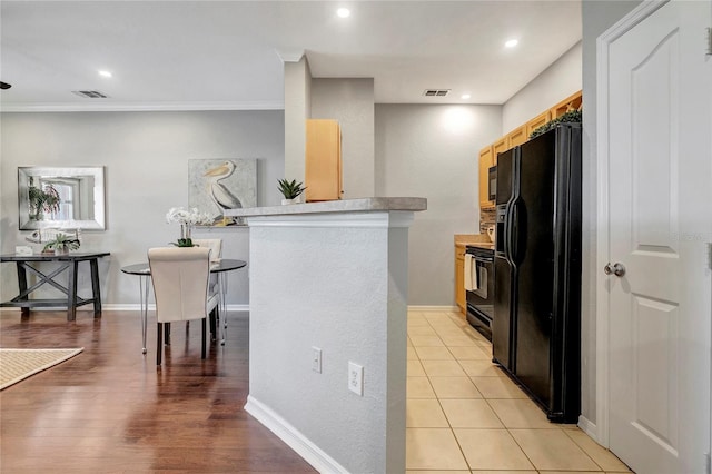 5000 Culbreath Key Way Unit 8-106, Tampa, FL 33611 - kitchen featuring black fridge, range, a peninsula, light countertops, and crown molding