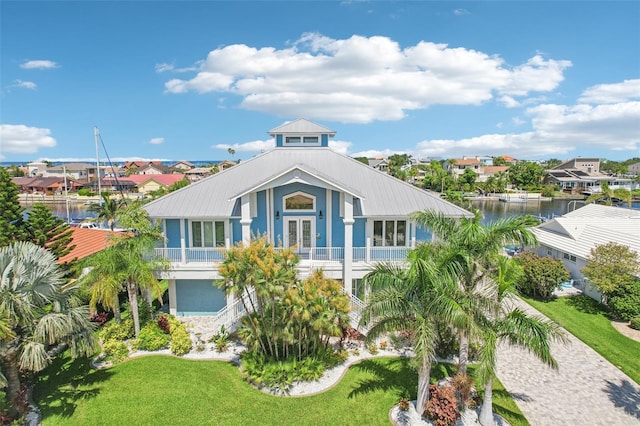5521 Windward Way, New Port Richey, FL 34652 - view of front of house featuring french doors, a water view, a front lawn, and a residential view