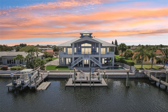 5521 Windward Way, New Port Richey, FL 34652 - back of property featuring stairs, a water view, boat lift, a patio, and a balcony