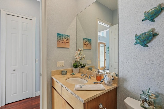 5521 Windward Way, New Port Richey, FL 34652 - half bath featuring a closet, vanity, wood finished floors, and a textured wall
