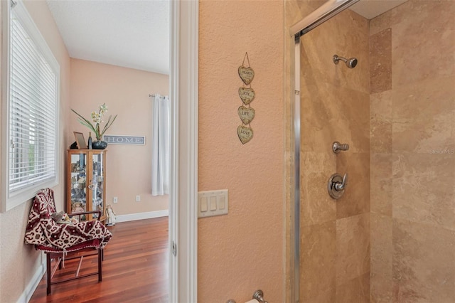 5521 Windward Way, New Port Richey, FL 34652 - bathroom view of tiled shower, wood finished floors, and a textured wall