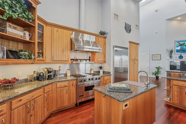 5521 Windward Way, New Port Richey, FL 34652 - kitchen with a high ceiling, wall chimney range hood, premium appliances, a center island with sink, and dark stone countertops
