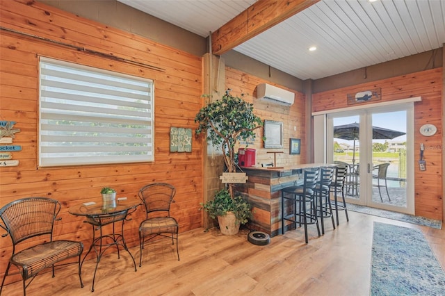 5521 Windward Way, New Port Richey, FL 34652 - dining area featuring wooden walls, wood finished floors, an AC wall unit, beam ceiling, and french doors