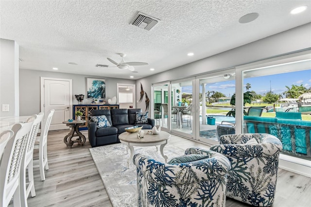 11599 Grove St, Seminole, FL 33772 - living area with a textured ceiling, a ceiling fan, light wood finished floors, recessed lighting, and a water view