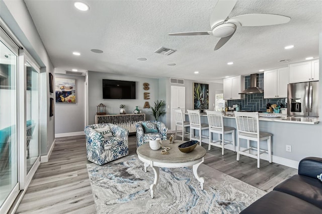 11599 Grove St, Seminole, FL 33772 - living room featuring ceiling fan, light wood finished floors, a textured ceiling, and recessed lighting