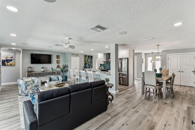 11599 Grove St, Seminole, FL 33772 - living room featuring light wood finished floors, a ceiling fan, a textured ceiling, and recessed lighting
