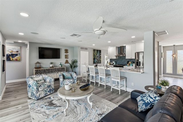 11599 Grove St, Seminole, FL 33772 - living room with a ceiling fan, light wood-type flooring, a textured ceiling, and recessed lighting
