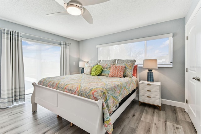 11599 Grove St, Seminole, FL 33772 - bedroom featuring multiple windows, wood finished floors, a textured ceiling, and ceiling fan