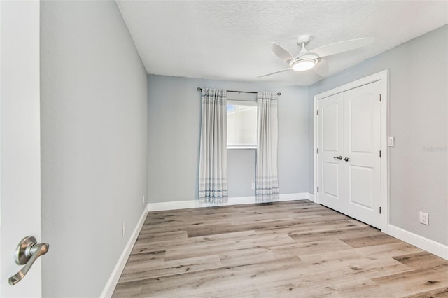 11599 Grove St, Seminole, FL 33772 - unfurnished bedroom featuring wood finished floors, a ceiling fan, a closet, and a textured ceiling
