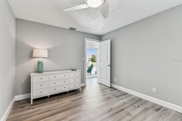11599 Grove St, Seminole, FL 33772 - bedroom featuring light wood-style flooring, a textured ceiling, and ceiling fan