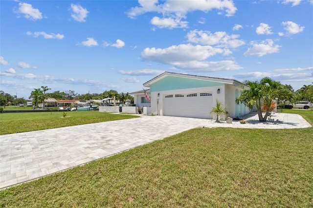 11599 Grove St, Seminole, FL 33772 - view of side of property with a garage, a lawn, decorative driveway, and stucco siding
