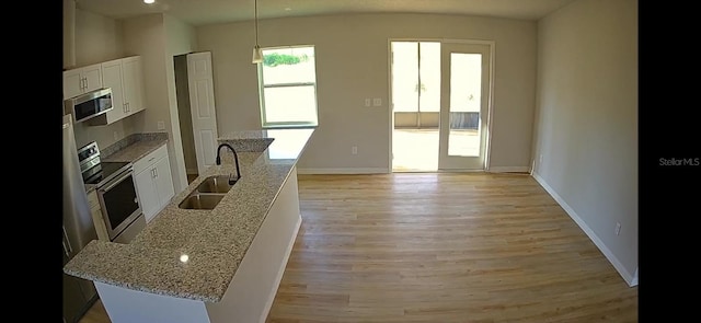 4251 E Walker St, Inverness, FL 34453 - kitchen featuring stainless steel appliances, white cabinetry, light wood-style floors, light stone counters, and decorative light fixtures