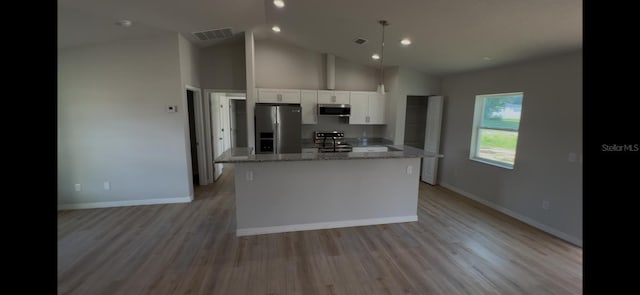 4251 E Walker St, Inverness, FL 34453 - kitchen featuring appliances with stainless steel finishes, white cabinetry, a center island, light stone countertops, and light wood-style floors