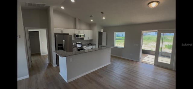 4251 E Walker St, Inverness, FL 34453 - kitchen with stainless steel appliances, white cabinetry, high vaulted ceiling, a kitchen island with sink, and light wood-style flooring