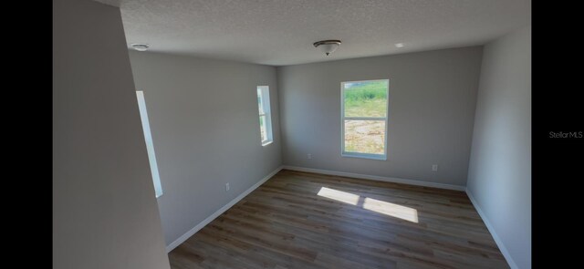 4251 E Walker St, Inverness, FL 34453 - unfurnished room featuring wood finished floors, a textured ceiling, and a smoke detector