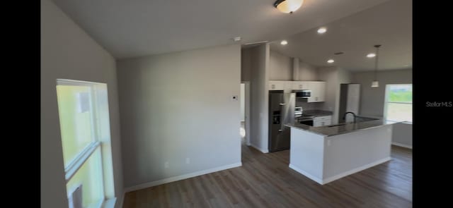 4251 E Walker St, Inverness, FL 34453 - kitchen with appliances with stainless steel finishes, white cabinetry, vaulted ceiling, a center island with sink, and wood finished floors