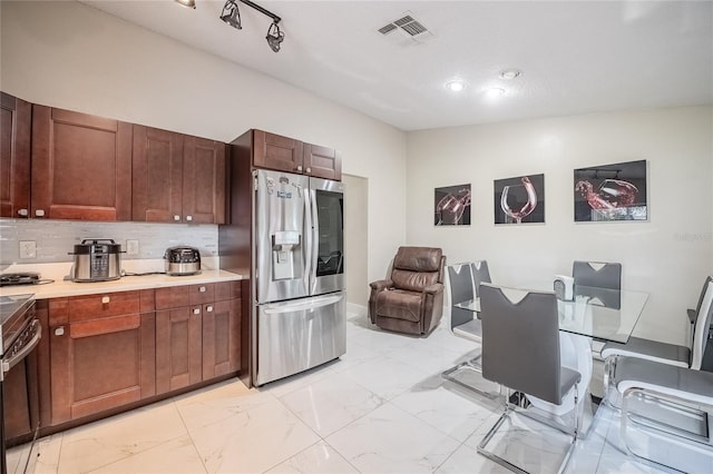 1100 Lowry Ave Unit 7, Lakeland, FL 33801 - kitchen featuring stainless steel fridge with ice dispenser, light marble finish flooring, light countertops, and tasteful backsplash