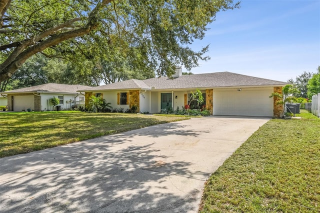 2004 Varner Cir, Winter Haven, FL 33884 - ranch-style home featuring a garage, concrete driveway, a chimney, a front yard, and stone siding