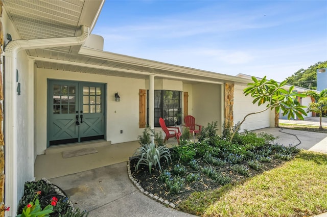 2004 Varner Cir, Winter Haven, FL 33884 - doorway to property featuring an attached garage, covered porch, concrete driveway, and stucco siding