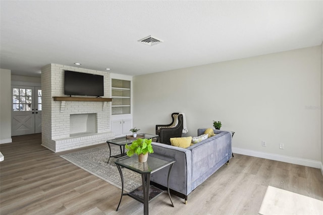 2004 Varner Cir, Winter Haven, FL 33884 - living area featuring wood finished floors, built in features, and a fireplace