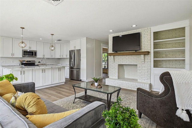 2004 Varner Cir, Winter Haven, FL 33884 - living area with light wood-style floors, recessed lighting, and a fireplace